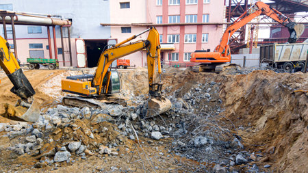 Powerful excavators dismantle concrete. Construction site. Dismantling of an industrial building....