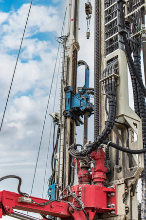 Work of a drilling rig at a construction site against a background of blue sky. Exploration of useful minerals. Industry and constructionの写真素材