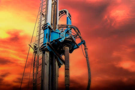 The work of the drilling rig at the construction site against the backdrop of the sunset....