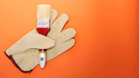Glove in which the paint brush is clamped. Surface painting. Means of protection. Bright orange...