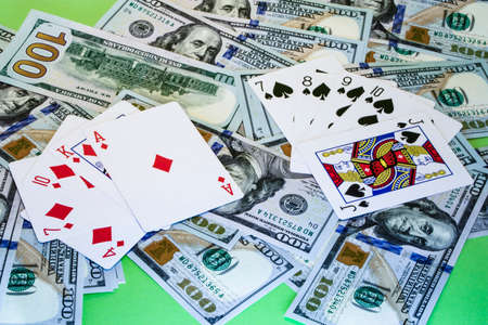 Poker combinations of cards on the background of dollar billsの写真素材