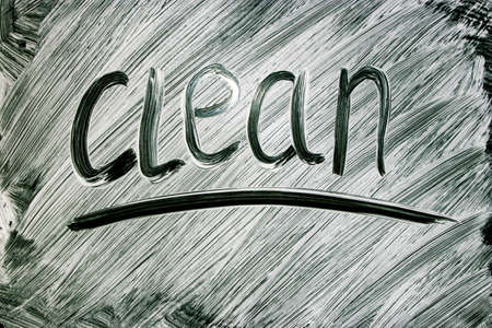 The inscription clean on black dirty glass. Clean surface. Cleaning. Cleaning concept.の写真素材