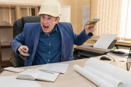 The boss in a construction helmet holds a wad of money in his hands and yells at his subordinate. Low revenue. Business manの写真素材