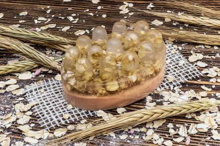 Handmade soap with oatmeal on a wooden background with ears. Natural organic home cosmetics for skin care. Skin scrubの写真素材