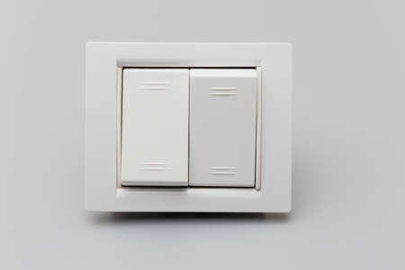 Two-button white switch on a gray background. Home electrician for repair. Energy saving concept....