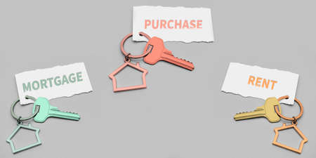 The concept of mortgage and rental housing and real estate. Keys with keychains in the form of...