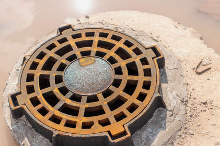 Storm sewer road hatch. Close-up. Road works. Collection and disposal of rainwater from the streetの写真素材