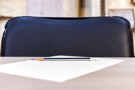 Pencil in the office on the table on a sheet of white paper. Minimalism. Copy space
