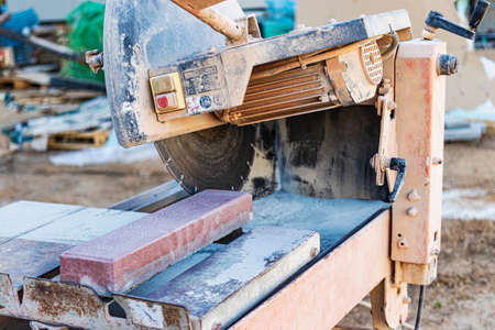 The circular diamond saw cuts concrete paving slabs. Concrete cutting machine close-up
