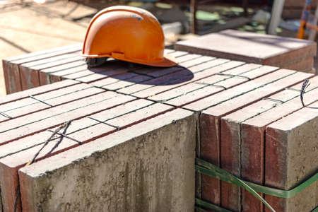 An old work helmet rests on folded paving slabs. Rest break at the construction site. Hard work of a builderの写真素材