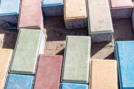 Pavement repair and laying of paving slabs on the walkway, stacked tile cubes on the background. Laying paving slabs in the pedestrian zone of the city, sand fillingの写真素材