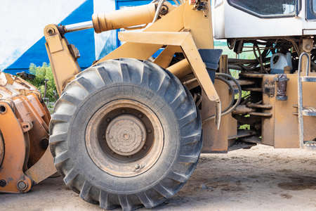 Heavy wheel loader with a bucket at a construction site. Equipment for earthworks, transportation and loading of bulk materials - earth, sand, crushed stoneの写真素材