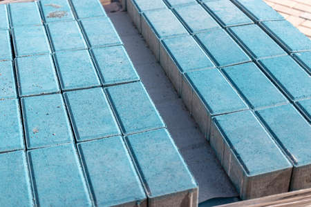 Storage of paving slabs on pallets at the construction site. Ready-to-install concrete paving slabs. Finished products warehouseの写真素材