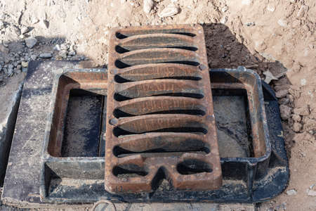Storm sewer road hatch ready for installation. Close-up. Road works. Collection and disposal of rainwater from the streetの写真素材