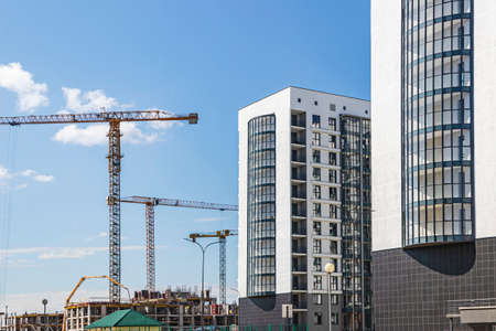 Construction of a monolithic reinforced concrete house. Tower cranes against the sky. Construction...