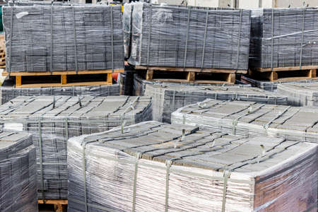 Storage of paving slabs on pallets at the construction site. Ready-to-install concrete paving slabs. Finished products warehouseの写真素材
