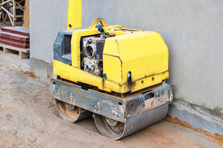Manual compact asphalt roller for tamping soil at a construction site