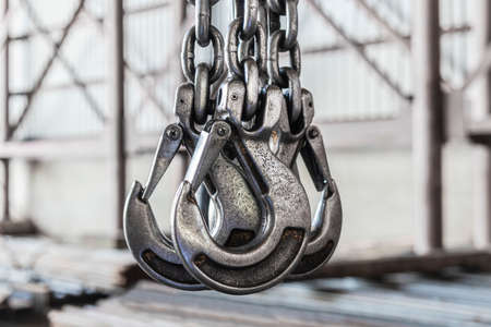 Lifting mechanism iron chain with a hook of an overhead crane on the background of an industrial enterprise or factoryの写真素材