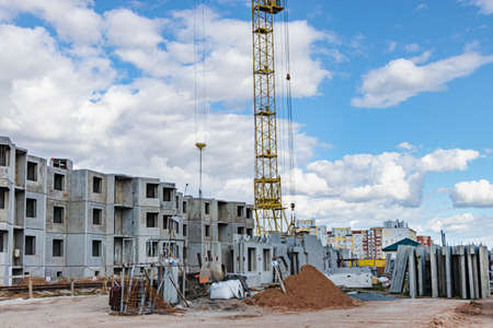 The work of tower cranes against the background of the sunset sky. Modern housing construction. Industrial engineering. Construction of mortgage housingの写真素材