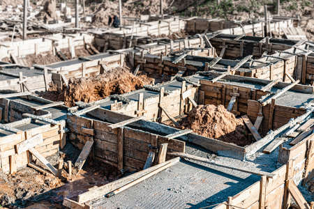 Strip foundations with formwork during the construction of a house. Reliable reinforced concrete foundation. Construction siteの写真素材