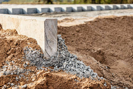Pavement repair and laying of paving slabs on the walkway, stacked tile cubes on the background. Laying paving slabs in the pedestrian zone of the city, sand filling. Road tiles and curbsの写真素材