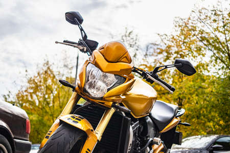 A yellow sports bike in a parking lot in the courtyard of an apartment building. Transport storage