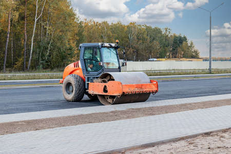 Heavy-duty vibratory roller for asphalt paving. Road construction. Construction of roads and urban...
