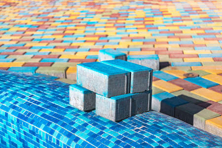 Pavement repair and laying of paving slabs on the walkway, stacked tile cubes on the background. Laying paving slabs in the pedestrian zone of the city, sand fillingの写真素材