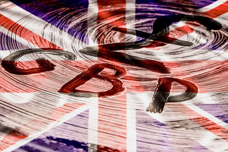 Sign of the Pound Sterling against the background of the flag of Great Britain
