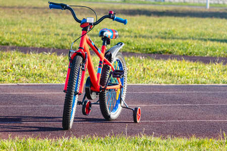 Children's bike on the sports track. Balance bike for kids. Teaching a child to play sports