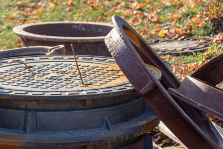 New cast-iron hatches prepared for installation at the construction site. Hatches with covers lie on...