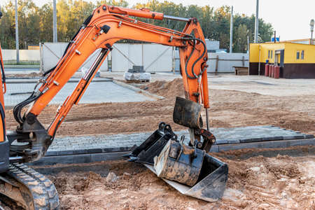 Mini excavator at the construction site. Compact construction equipment for earthworks