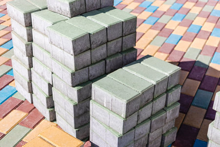 Multi-colored paving slabs. Pavement repairs and paving slabs laying on the roadway, with tile cubes in the background. Laying of paving slabs in the pedestrian zone of the city, improvementの写真素材