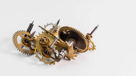 Old clockwork mechanisms on a white background. Gear wheels, pulleys, mechanical watch parts. Macro photography. Full focus. The concept of the passing timeの写真素材