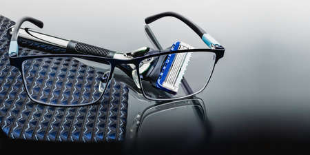 Modern mens razor with glasses and a business suit tie. Fashionable men's accessories. A holiday gift for a business man. Things for a business tripの写真素材