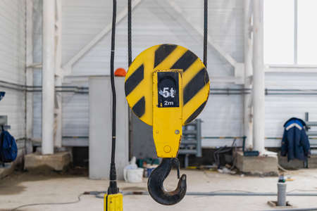 Crane chain and hook blurred warehouse background with remote control. Concept production steel...