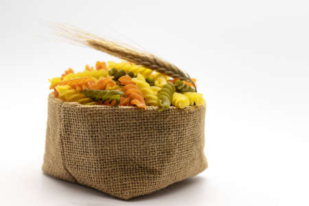 Pasta from durum wheat in a canvas bag on a white background. close-up. Italian pastaの写真素材