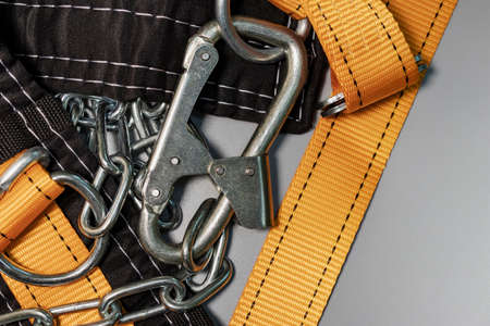 Safety belt for work at height with carabiner. Professional safety equipment for mountaineering and construction. safety precautions. close-upの写真素材