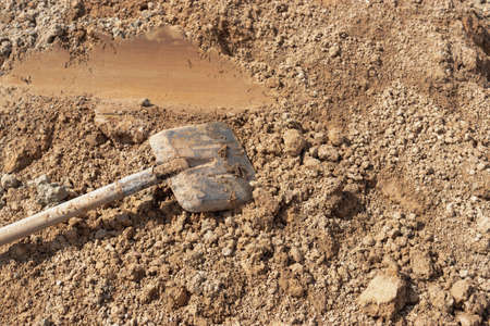 Old rusty shovel in sand on building