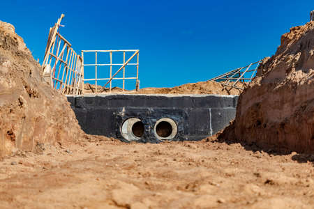 Laying of underground pipes in concrete chamber. Installation of water main at the construction...