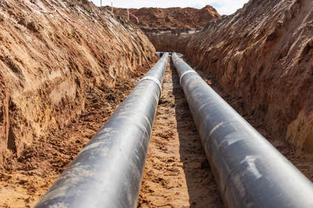 insulated pipe. Large metal pipes with a plastic sheath laid in a trench. Modern pipeline for...