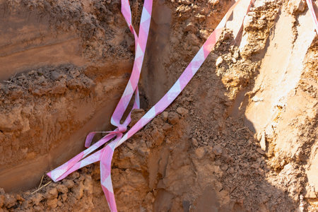 Soil on earth as texture and background. Warning or protective tape at a construction siteの写真素材