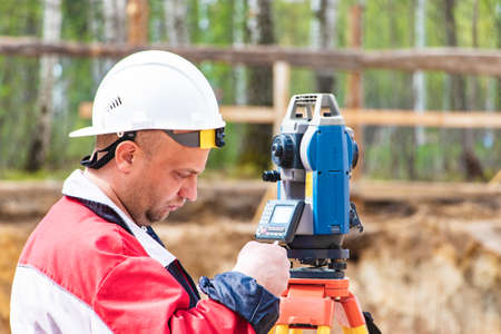 Construction of a residential area. geodetic stakeout. Surveyor at a large construction site. A man...