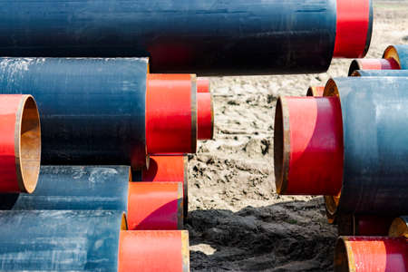 insulated pipe. Large metal pipes with a plastic sheath at a construction site. Modern pipeline for supplying hot water and heating to a residential areaの写真素材