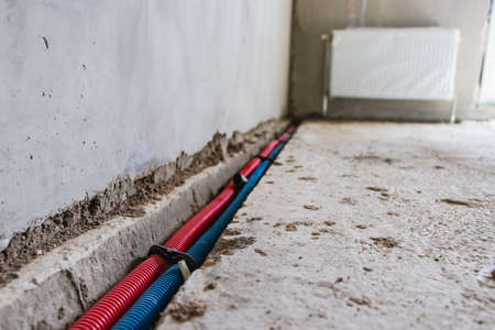 Pipe connection to batteries in the floor in a residential building. Wiring of communications in the...