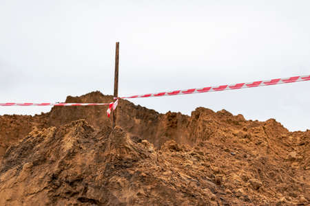 Soil on earth as texture and background. Warning or protective tape at a construction siteの写真素材