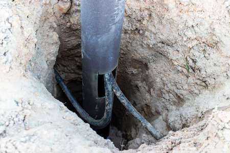 Lamp post with open hole. Inside is a power switch and electrical cables. Electrical connection for...