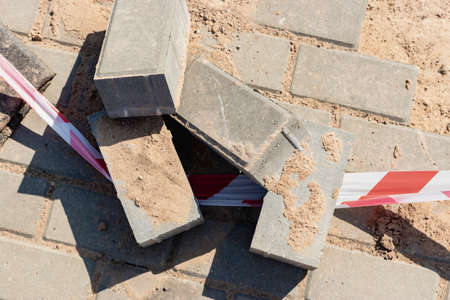 Pavement repairs and paving slabs laying on the prepared surface, with tile cubes in the background....