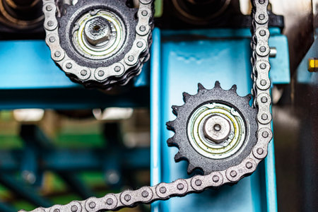 Rolls of an industrial machine for cutting metal with a chain transmission. Conveyor line in a...