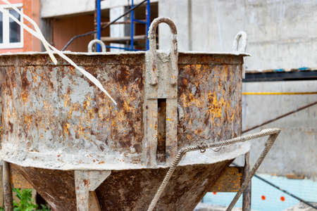 Cone tank for conveying and pouring concrete in monolithic construction by crane. A capacity for transporting concrete. Reinforced concrete monolithic work at the construction siteの写真素材